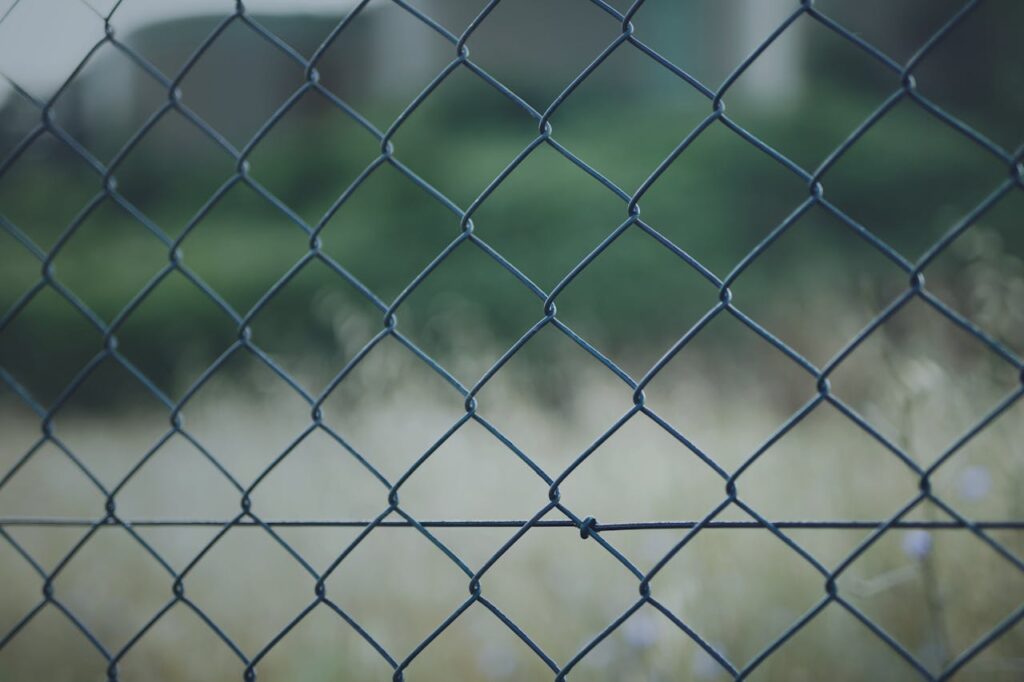 Detailed view of a chain link fence outdoors against a blurred natural background.